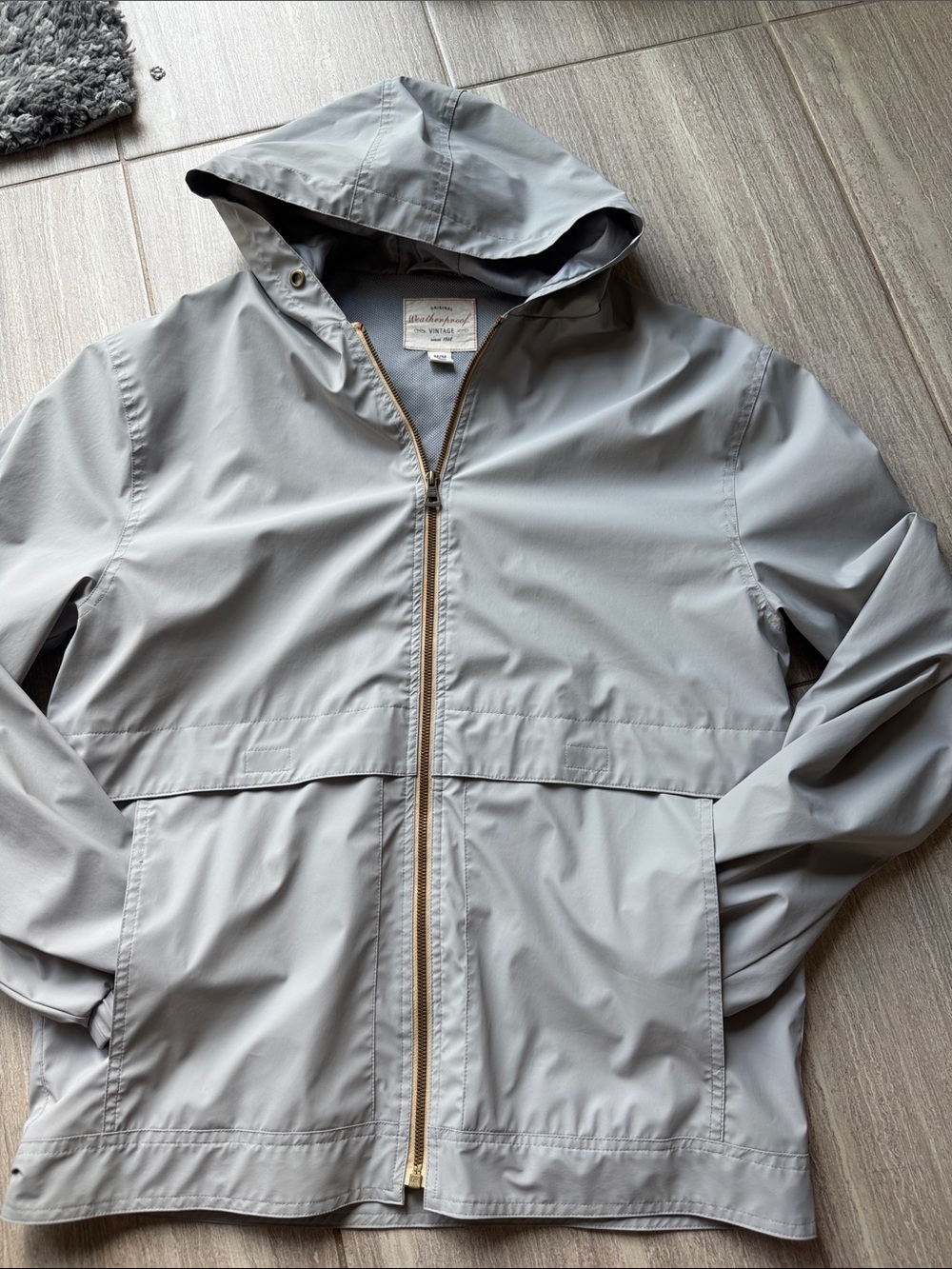 Weatherproof Light Gray Hooded Raincoat with Gold Zipper